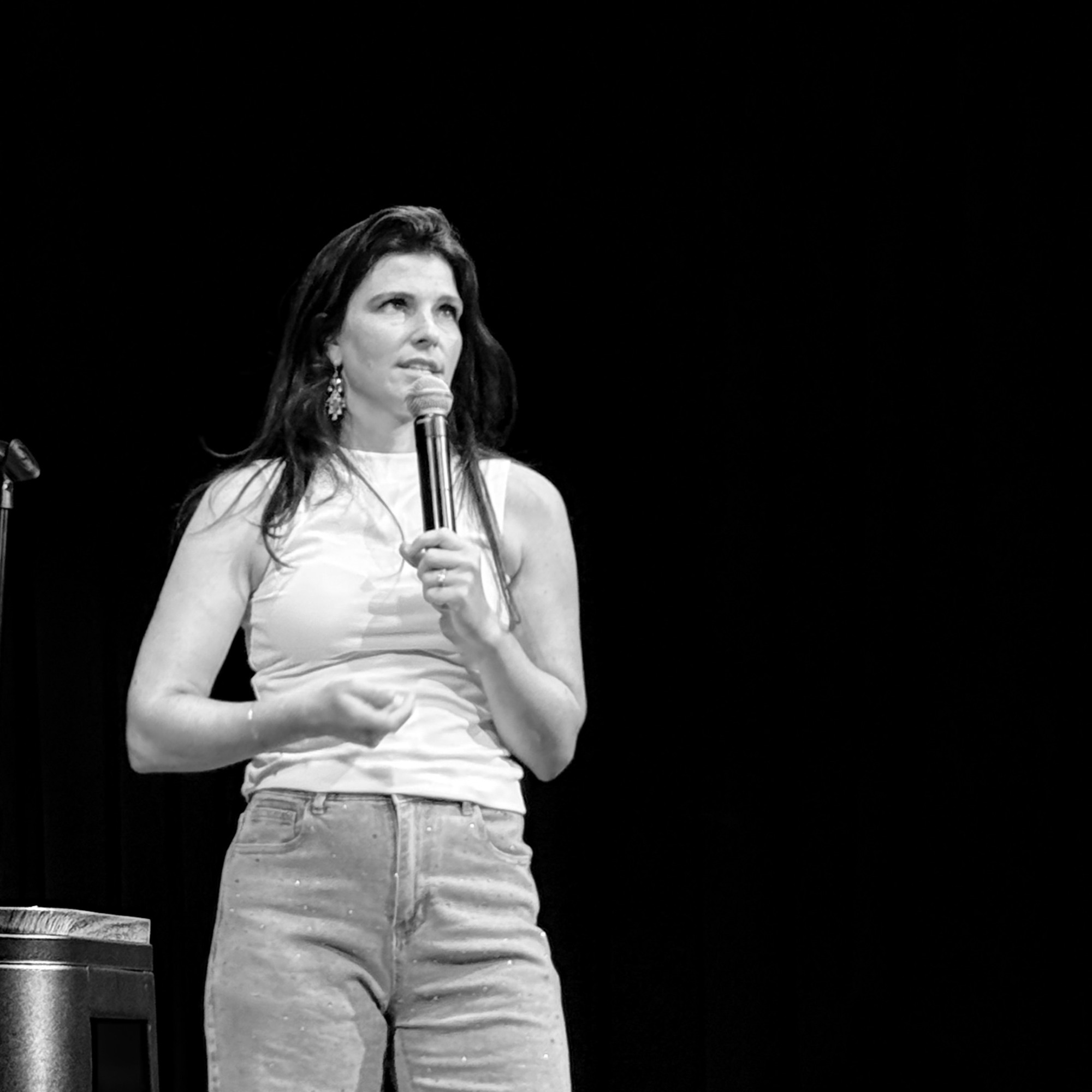 Black-and-white shot of a comedian mid-set at the Snowmass Live Comedy Series, The Collective Snowmass